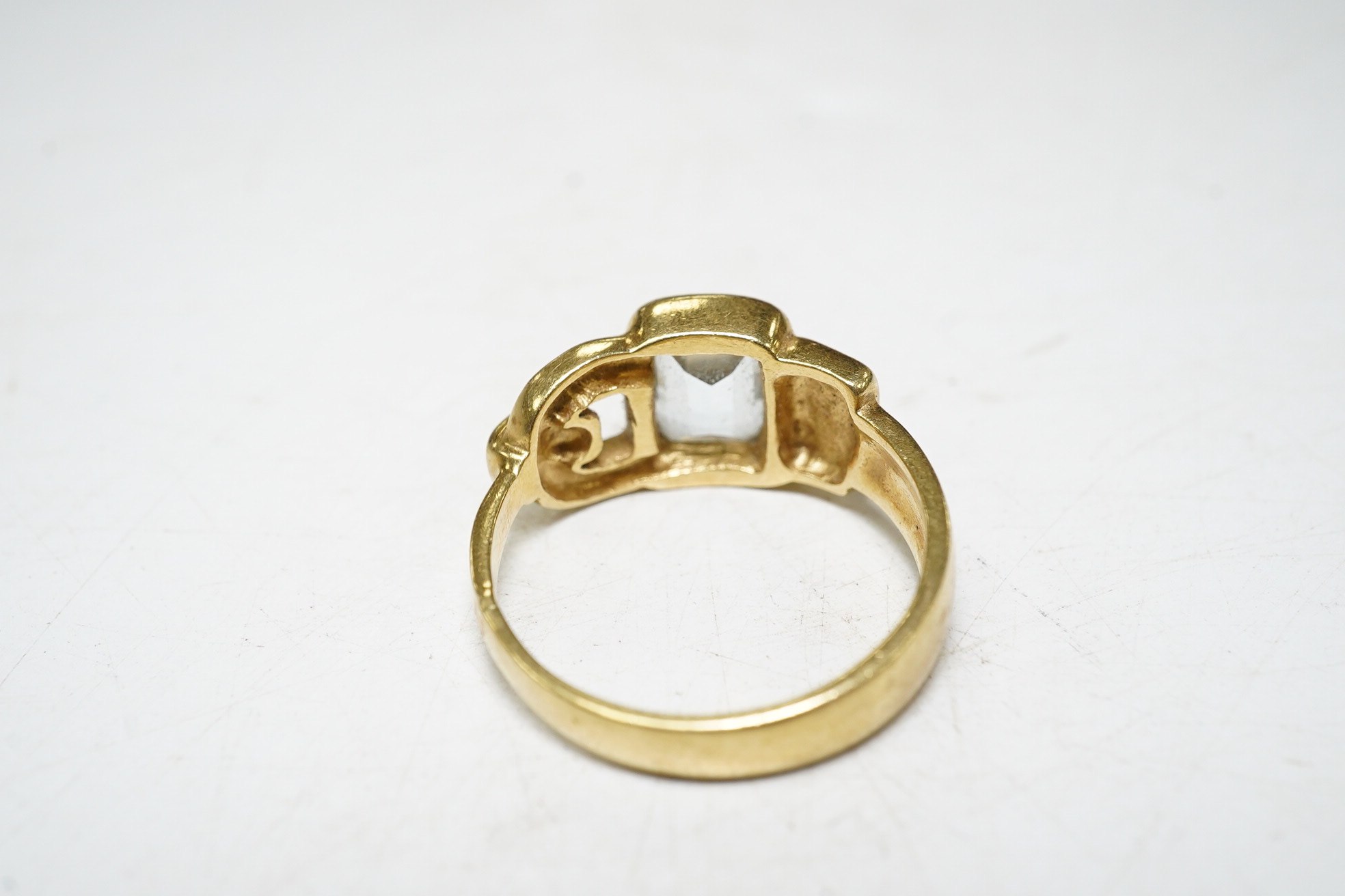 An 18ct gold aquamarine set buckle ring, size O, gross 6.1 grams Condition, fair.